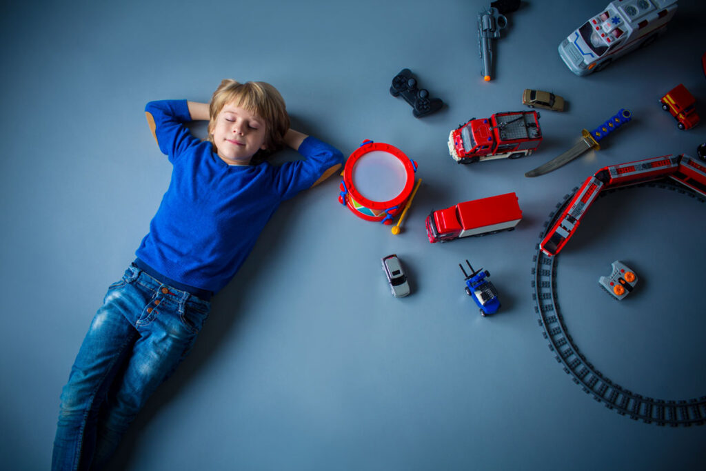 pe fundal albastru baiat de 9 ani si cadourile lui